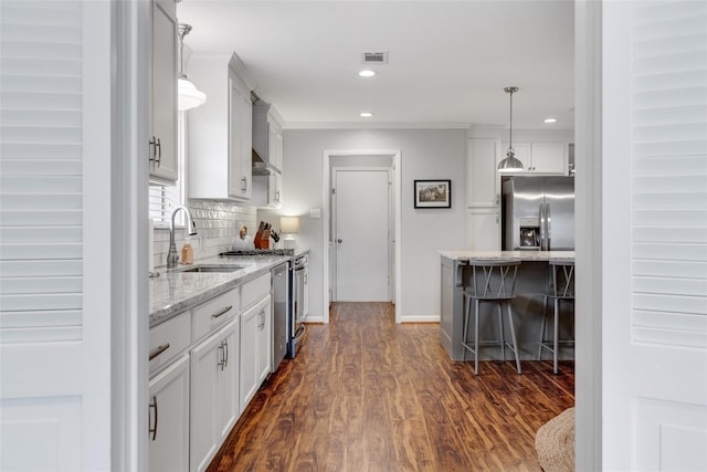 kitchen with decorative light fixtures, dark hardwood / wood-style floors, sink, and appliances with stainless steel finishes