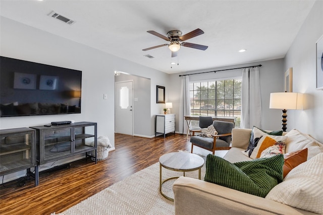 living room featuring ceiling fan and dark wood-type flooring