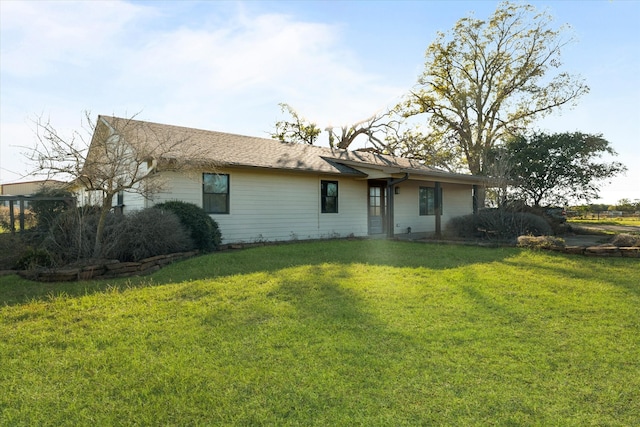 rear view of house featuring a lawn