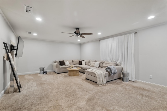 carpeted living room with ceiling fan and crown molding