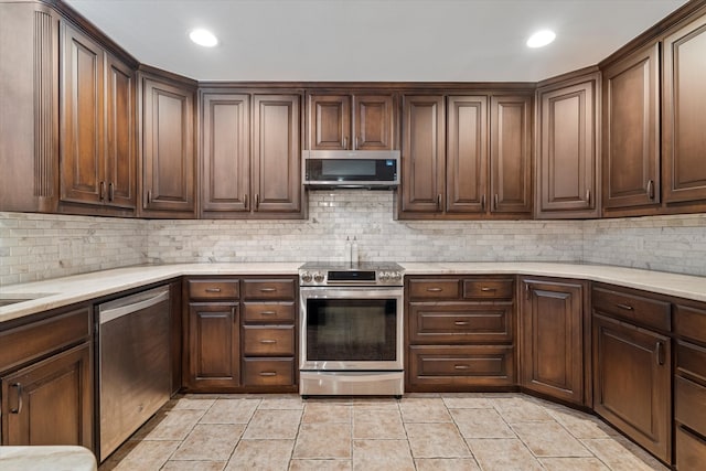 kitchen with appliances with stainless steel finishes, dark brown cabinetry, and tasteful backsplash