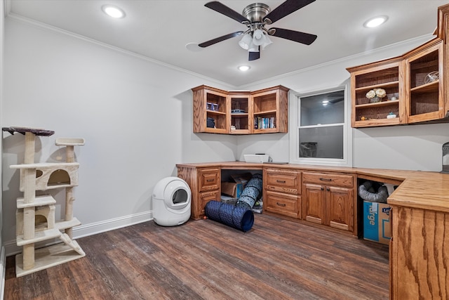 office space with ceiling fan, dark hardwood / wood-style flooring, built in desk, and ornamental molding