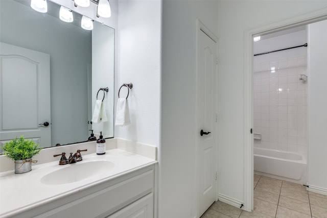 bathroom featuring tile patterned flooring, tiled shower / bath combo, and vanity