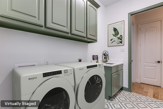 laundry room featuring cabinets, light hardwood / wood-style floors, washer and clothes dryer, and sink