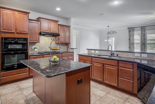 kitchen with sink, decorative backsplash, black appliances, and a center island