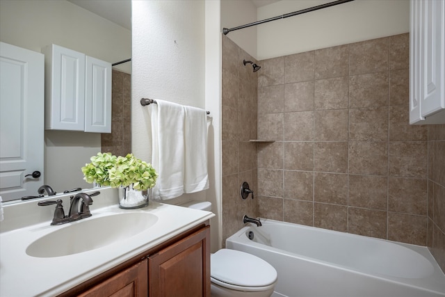 full bathroom with vanity, tiled shower / bath, and toilet