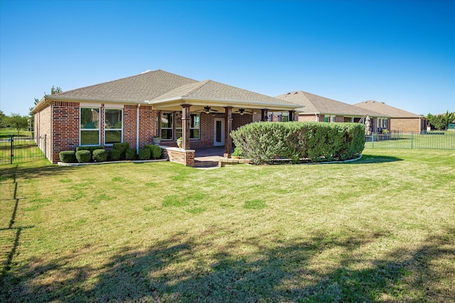 rear view of house with a lawn and ceiling fan