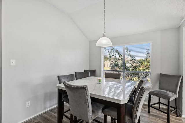 dining room with lofted ceiling and wood-type flooring