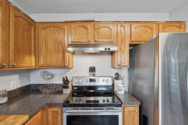 kitchen featuring a textured ceiling, stainless steel appliances, and exhaust hood