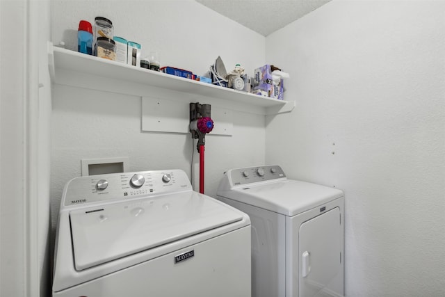 laundry area with washing machine and dryer and a textured ceiling