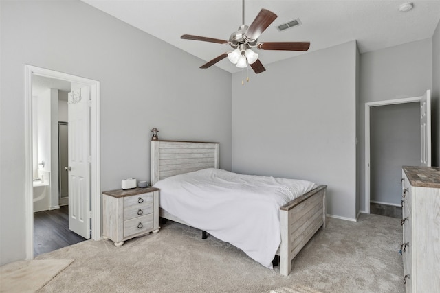 carpeted bedroom with ensuite bath and ceiling fan