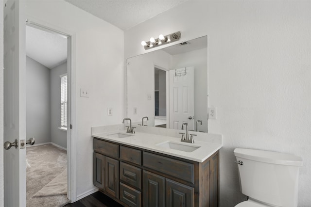 bathroom with vanity, a textured ceiling, and toilet