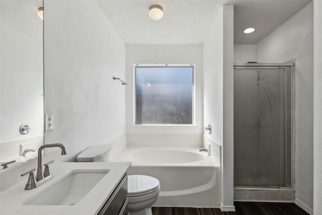 full bathroom featuring hardwood / wood-style flooring, vanity, separate shower and tub, and a textured ceiling