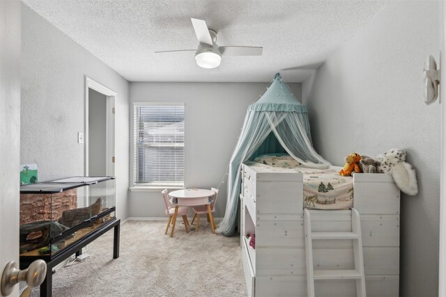 carpeted bedroom with ceiling fan and a textured ceiling