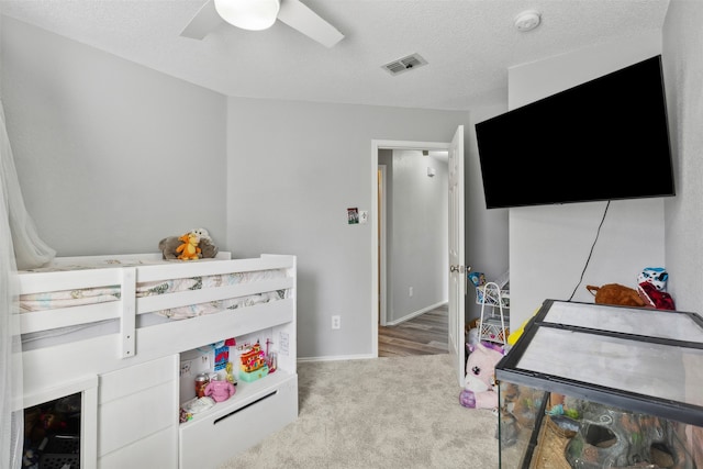 carpeted bedroom with a textured ceiling and ceiling fan