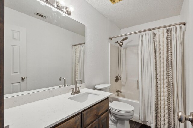 full bathroom with vanity, shower / bath combination with curtain, a textured ceiling, and toilet