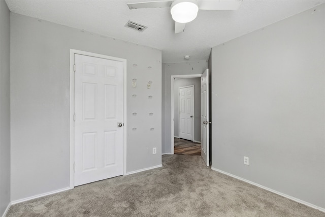 unfurnished bedroom with a textured ceiling, light colored carpet, and ceiling fan