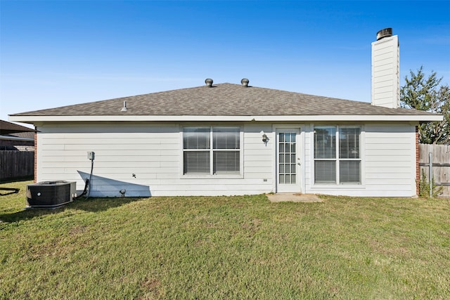 back of house with a lawn and cooling unit