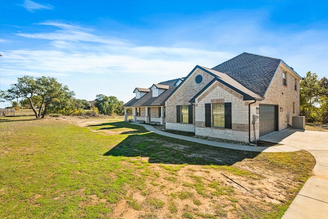 view of front facade featuring central air condition unit, a front lawn, and a garage