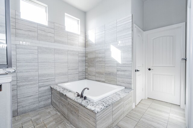 bathroom featuring a tile shower and vanity