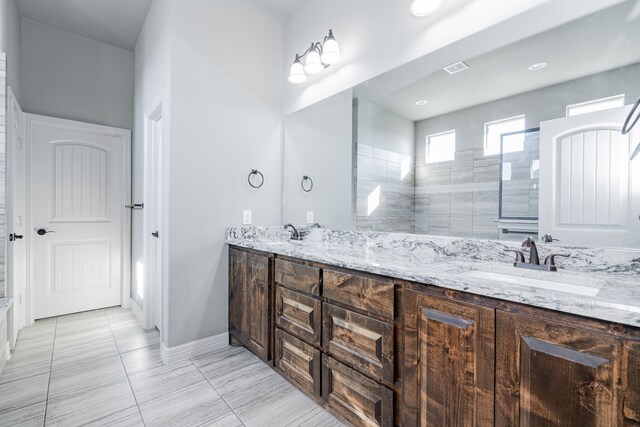 bathroom with tile patterned flooring, a tile shower, vanity, and ceiling fan