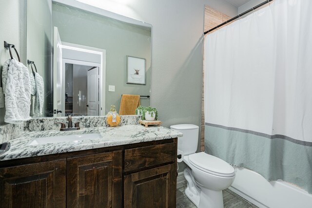 bathroom with walk in shower, vanity, and toilet