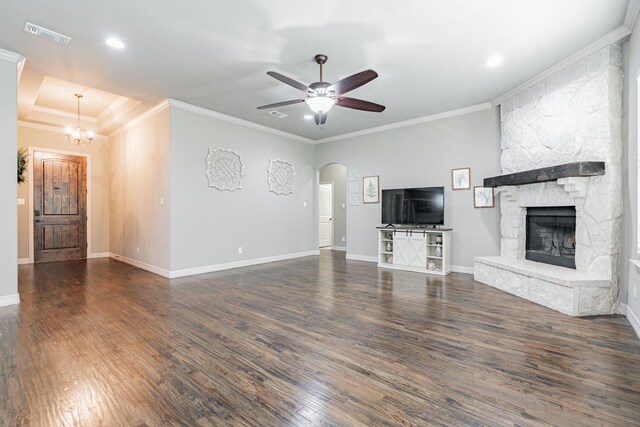 unfurnished living room featuring crown molding, a fireplace, ceiling fan, and dark wood-type flooring