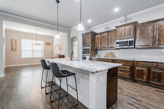 kitchen featuring decorative backsplash, appliances with stainless steel finishes, light stone countertops, dark brown cabinets, and dark wood-type flooring