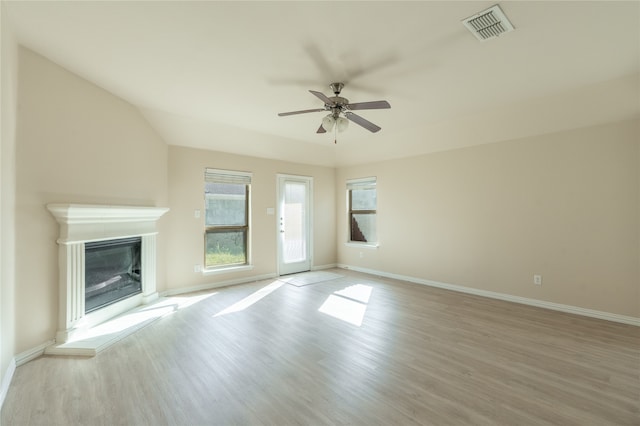 unfurnished living room with light hardwood / wood-style floors, vaulted ceiling, and ceiling fan