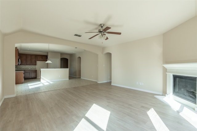 unfurnished living room featuring light hardwood / wood-style flooring, ceiling fan, and lofted ceiling