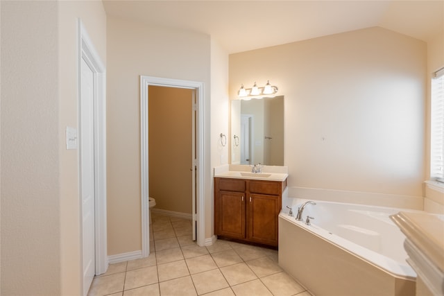 bathroom featuring vanity, lofted ceiling, a bath, tile patterned flooring, and toilet