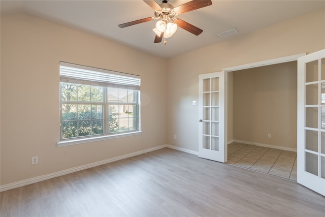 empty room featuring french doors, light hardwood / wood-style flooring, and ceiling fan