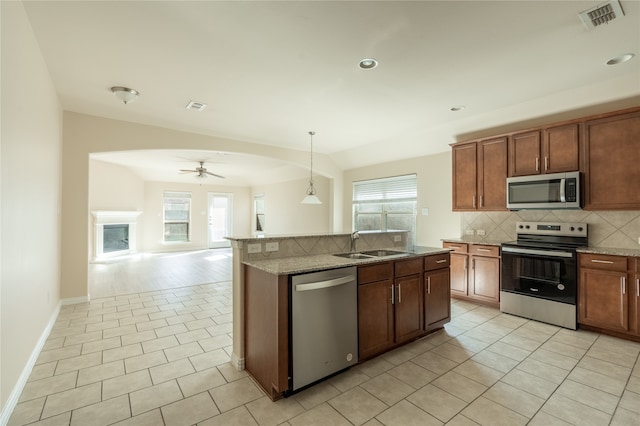 kitchen with decorative light fixtures, stainless steel appliances, plenty of natural light, and ceiling fan