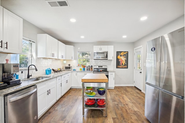 kitchen with butcher block counters, sink, appliances with stainless steel finishes, dark hardwood / wood-style flooring, and white cabinets