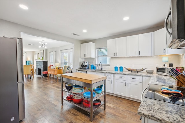 kitchen with white cabinetry, appliances with stainless steel finishes, sink, and wood-type flooring