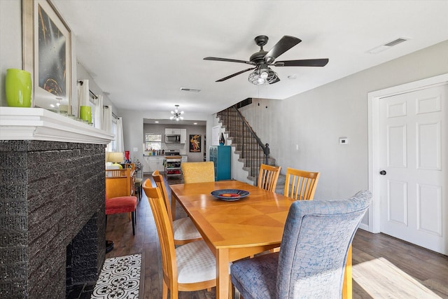 2505 Westbrook Ave, Fort Worth, TX 76111 - dining room with wood finished floors, stairs, a premium fireplace, and a ceiling fan