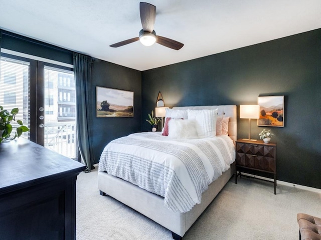 bedroom featuring access to outside, french doors, light colored carpet, and ceiling fan