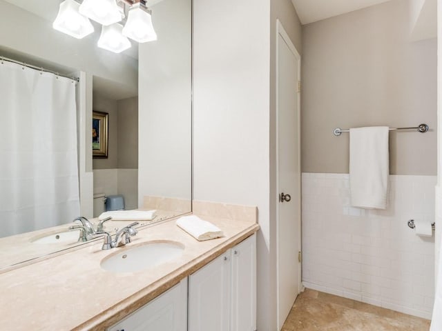 bathroom with tile patterned flooring, vanity, tile walls, and toilet