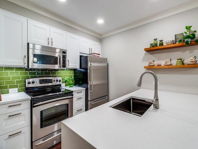 kitchen featuring white cabinetry, sink, tasteful backsplash, appliances with stainless steel finishes, and ornamental molding