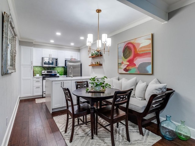 dining space featuring dark hardwood / wood-style floors, an inviting chandelier, and ornamental molding