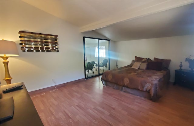 bedroom featuring vaulted ceiling with beams and hardwood / wood-style flooring