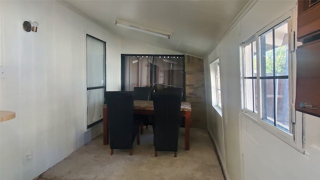 carpeted dining room with ornamental molding and lofted ceiling