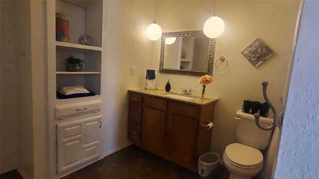 bathroom with built in features, vanity, and toilet