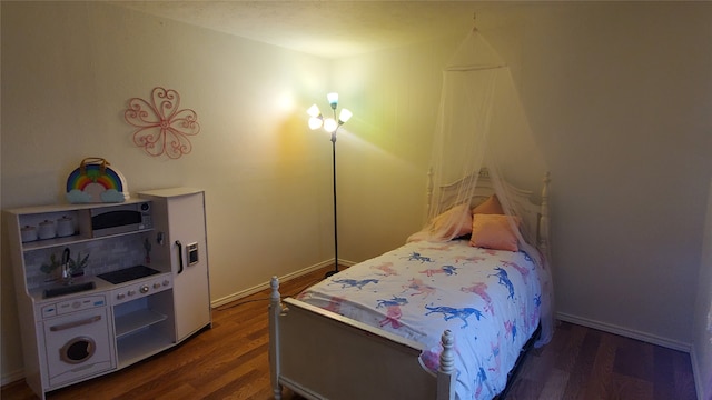 bedroom with dark hardwood / wood-style floors