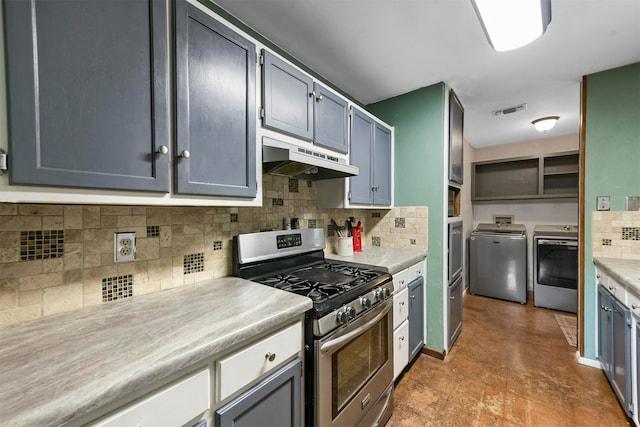 kitchen featuring washer and dryer, gas range, and backsplash