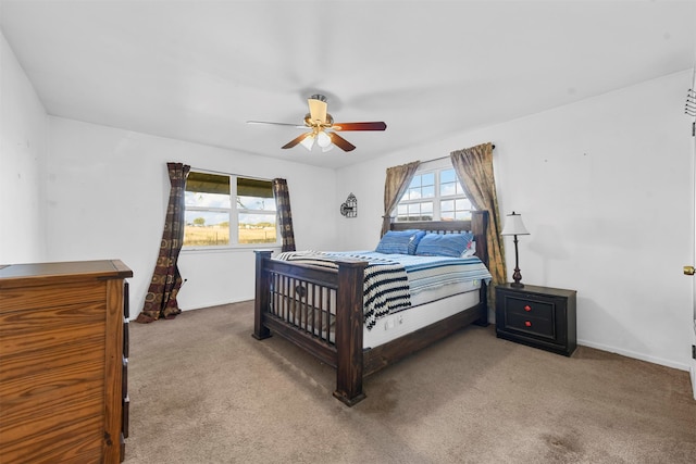 carpeted bedroom featuring multiple windows and ceiling fan