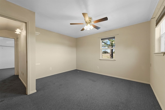 spare room with ceiling fan, lofted ceiling, and dark colored carpet