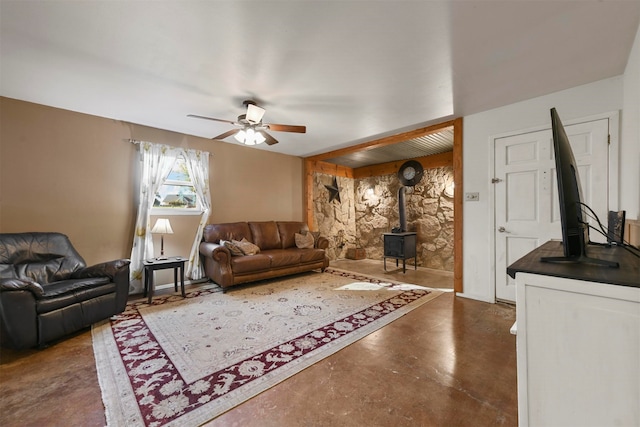 living room featuring a wood stove and ceiling fan