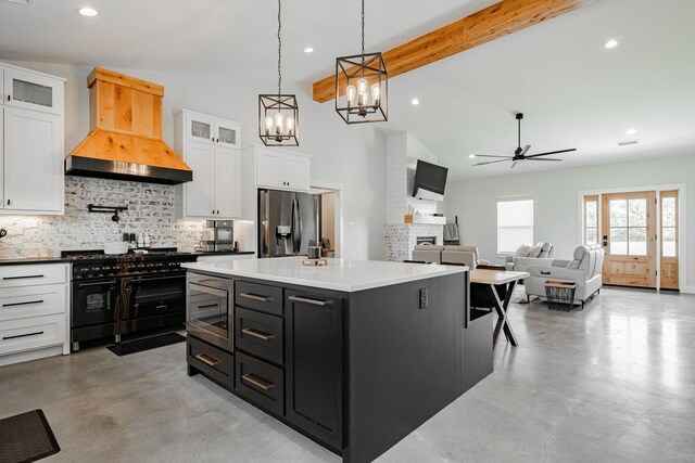 kitchen featuring white cabinetry, appliances with stainless steel finishes, dark cabinetry, and custom range hood