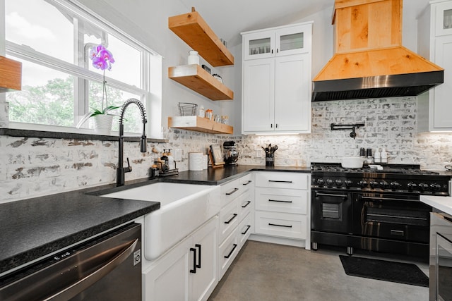 kitchen with a sink, range with two ovens, decorative backsplash, custom exhaust hood, and dishwasher